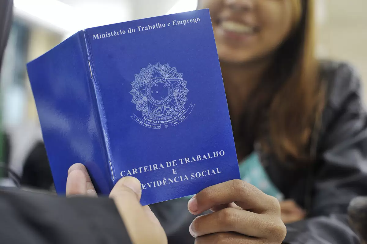 Imagem de alguém entregando sua carteira de trabalho.